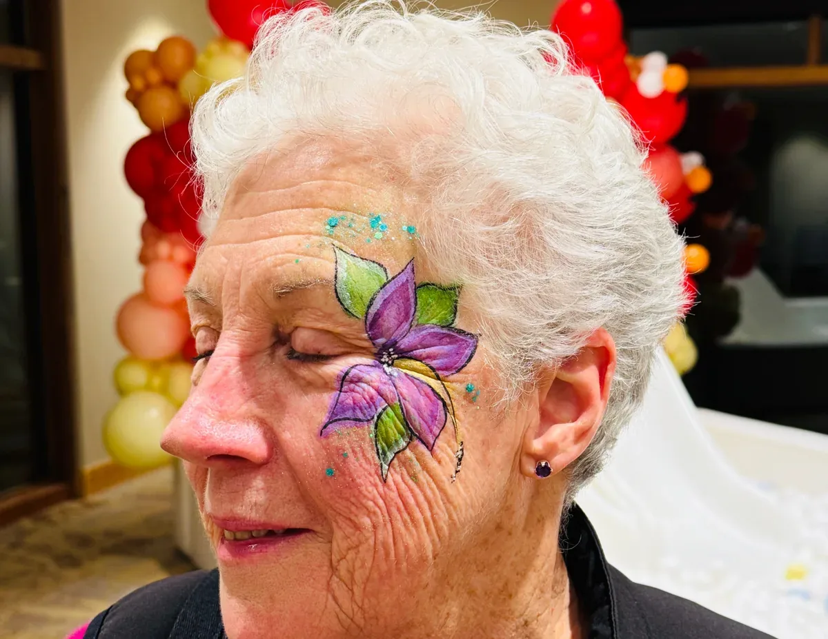 Adult with purple butterfly face painting from the Colory Faces portfolio.