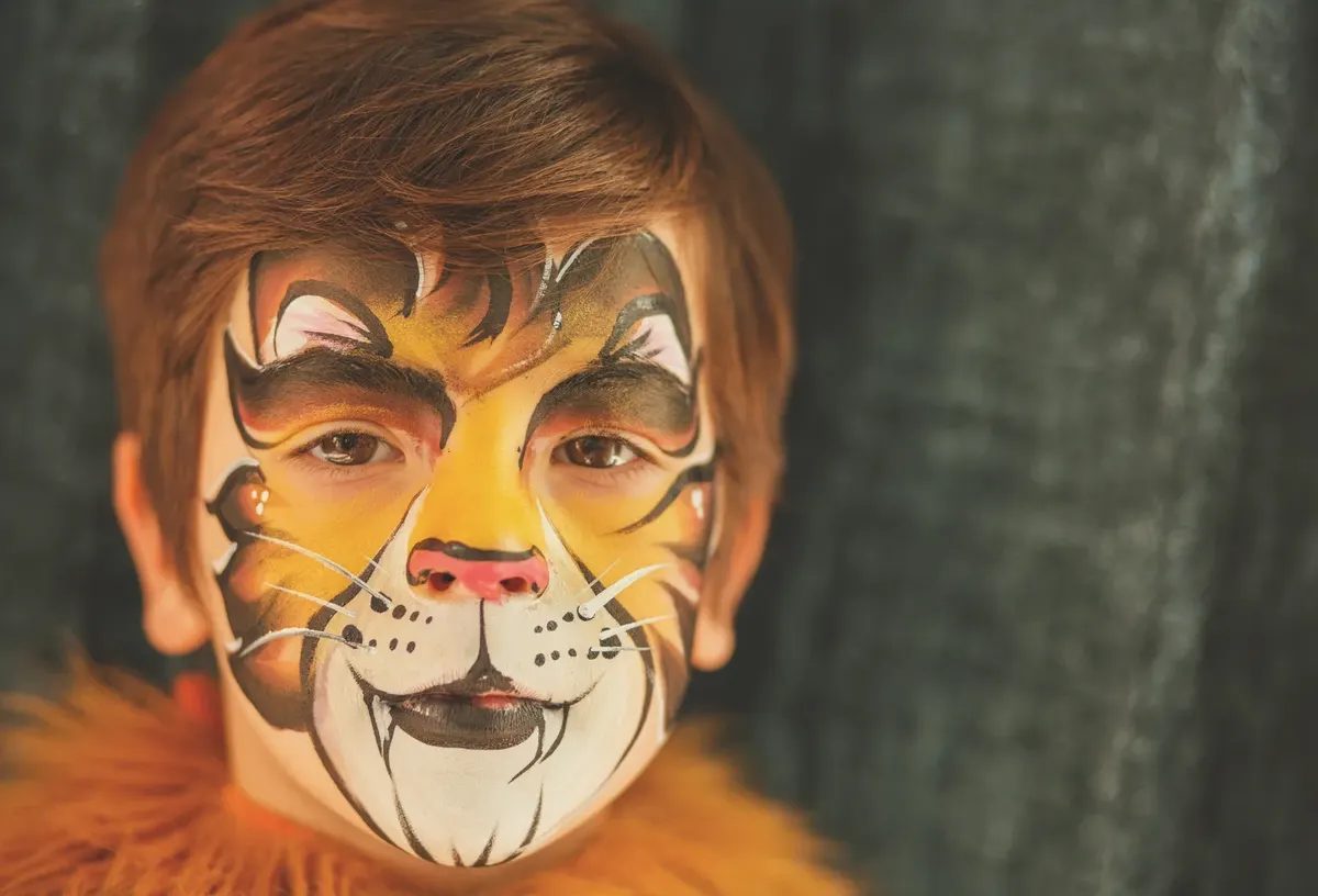 Child with full tiger face painting closeup.